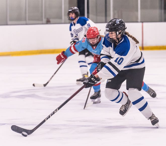 Lakeshore Lightning's Lauren Dykema (10) collects the puck during the game against Arrowhead at the Ozaukee Ice Center in Mequon on Wednesday, Nov. 29, 2023.