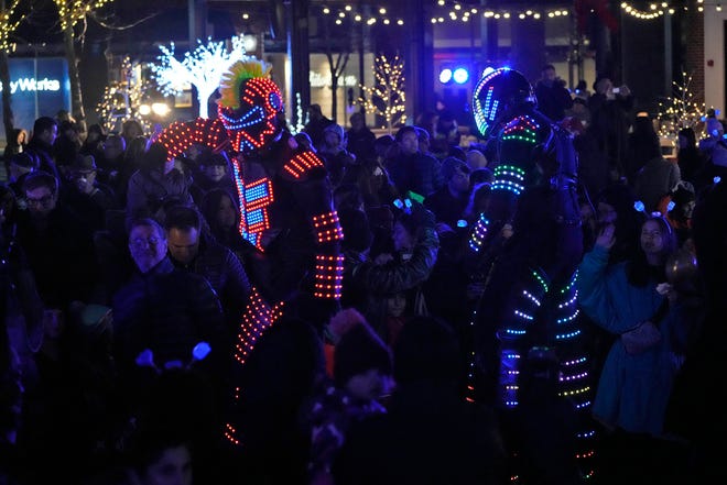 Dancers in stilts and LED suits dance to music dance as part of a Chanukah Festival and Gelt Drop, to kick off the first day of Chanukah, in The Yard at Bayshore in Glendale on Thursday, Dec. 7, 2023. The largest Hanukkah festival in Wisconsin, hosted by Lubavitch of Wisconsin, included live music, a giant Menorah lighting, and a mega gelt and gift drop.