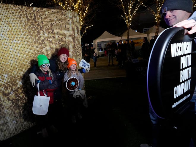 A family pose for a at the Wisconsin Photo Booth Company at the Chanukah Festival and Gelt Drop, to kick off the first day of Chanukah, in The Yard at Bayshore in Glendale on Thursday, Dec. 7, 2023. The largest Hanukkah festival in Wisconsin, hosted by Lubavitch of Wisconsin, included live music, a giant Menorah lighting, and a mega gelt and gift drop.