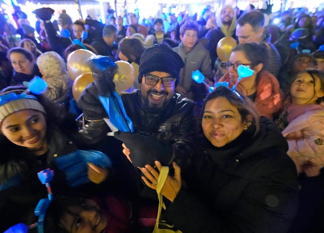 Robiul Foysal holds his parachute he caught tossed from a as part of a Chanukah Festival and Gelt Drop, to kick off the first day of Chanukah, in The Yard at Bayshore in Glendale on Thursday, Dec. 7, 2023. The largest Hanukkah festival in Wisconsin, hosted by Lubavitch of Wisconsin, included live music, a giant Menorah lighting, and a mega gelt and gift drop.