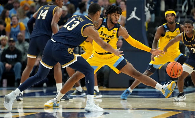 Notre Dame forward Tae Davis (13) passes around Marquette forward David Joplin (23) during the first half of their game Saturday, December 9, 2023 at Fiserv Forum in Milwaukee, Wisconsin.