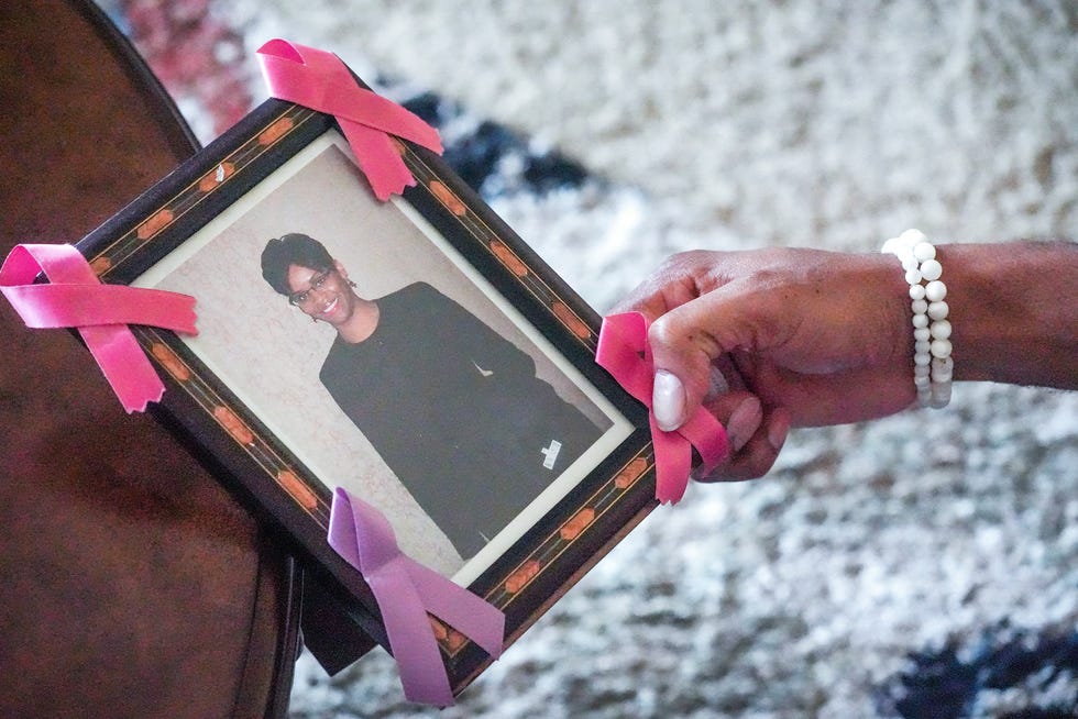 Michael Washington, retired MPD homicide detective, holds a photograph of Sherida Washington Davis, who was killed in 2017.