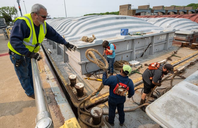 U.S. Army Corps of Engineers worker Eric Lockington grabs a line a crew member of the tug Theresa L. Wood  Wednesday, May 17, 2023 at Lock and Dam #8 in Genoa, Wis.  The locks allow the boats to gradually adjust to changing river levels. Most towboats can push 15 barges at a time on the river. When those barges reach a 600-foot long lock, they don’t fit. Instead, they have to be split up, which takes more than twice as long.It was constructed and was put into operation by April 1937.